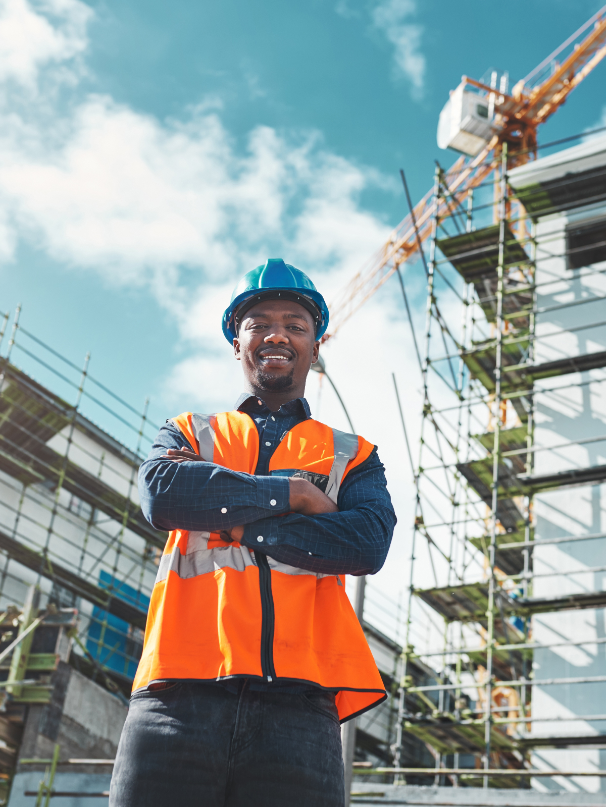 Smiling Best World site engineer in hi-vis vest and hard hat on an active construction site