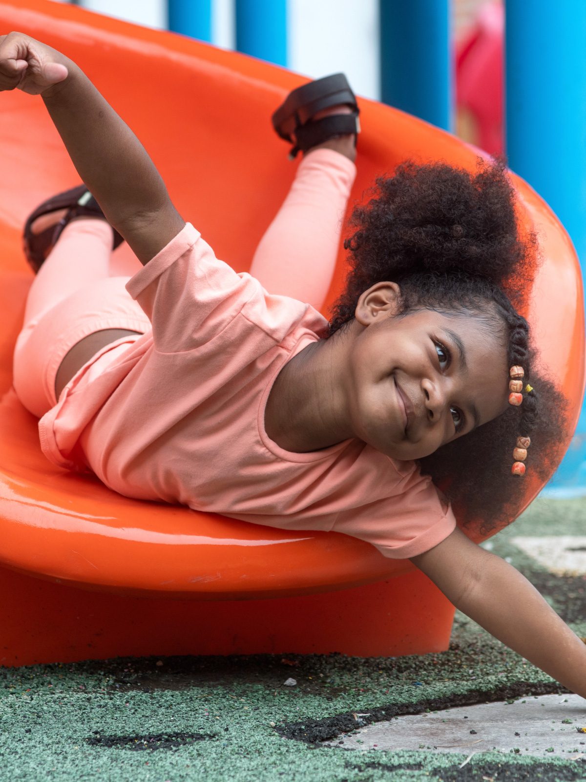 Child playing on a slide in a Best World community playground